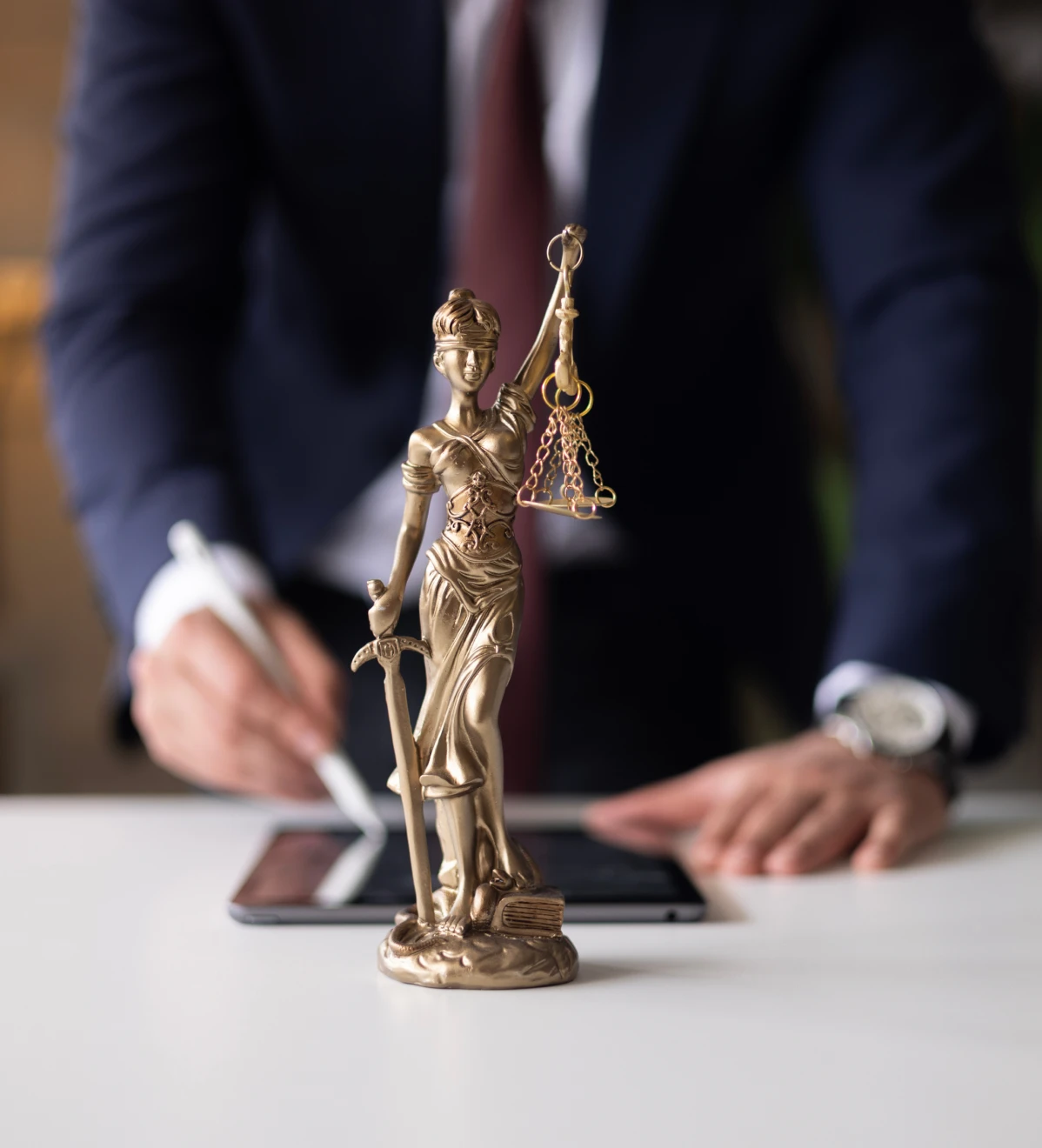 Legal professional with digital tablet and statue